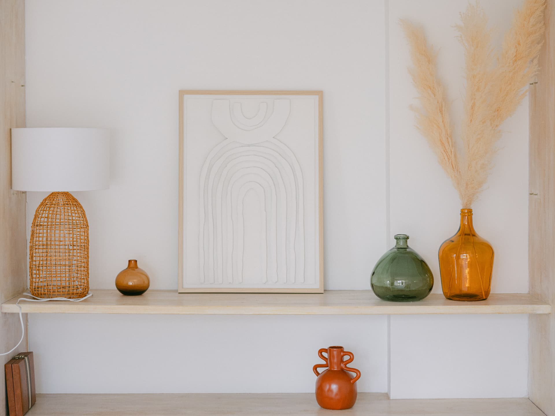 Étagère en bois clair ornée de vases, herbes de la pampa et objets décoratifs