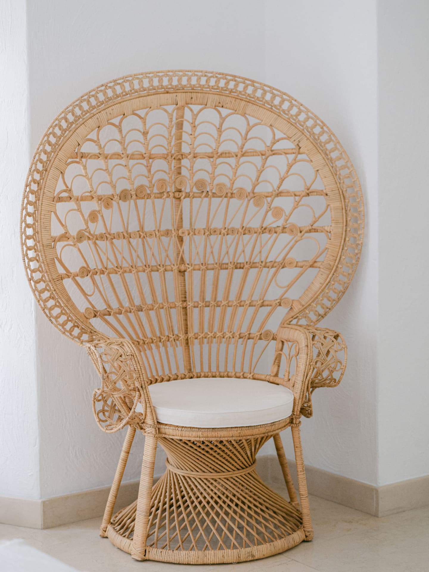 Fauteuil paon en rotin tressé au coussin blanc